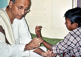 Dr. Vasant Lad checking a child's pulse